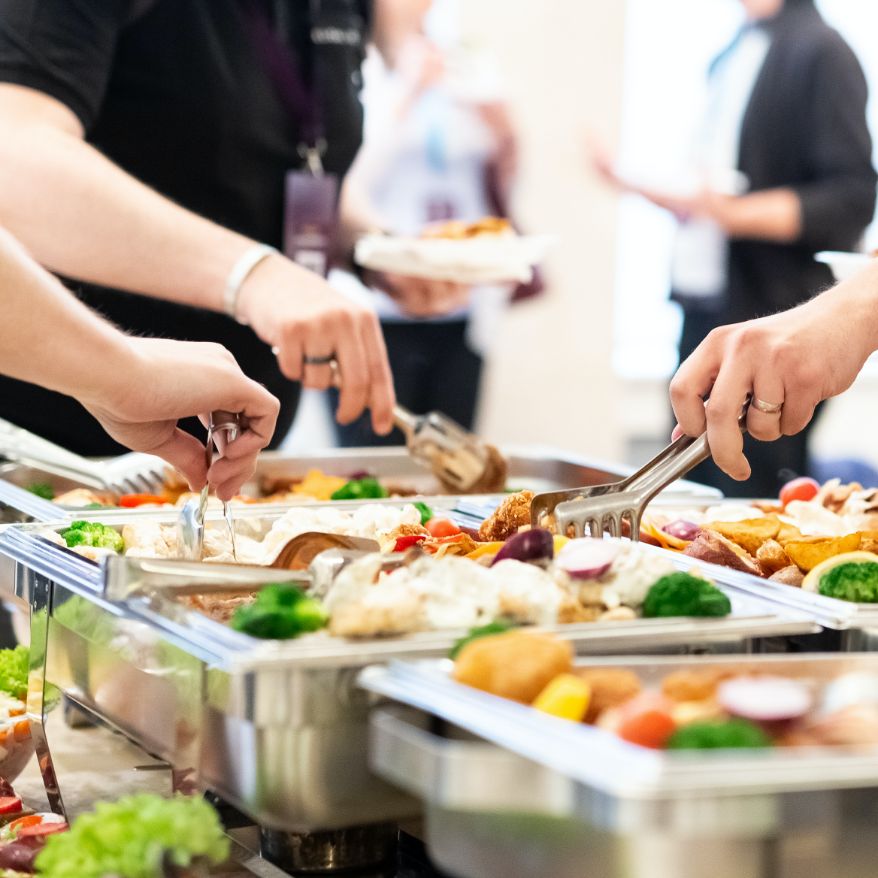 people serving food at a buffet