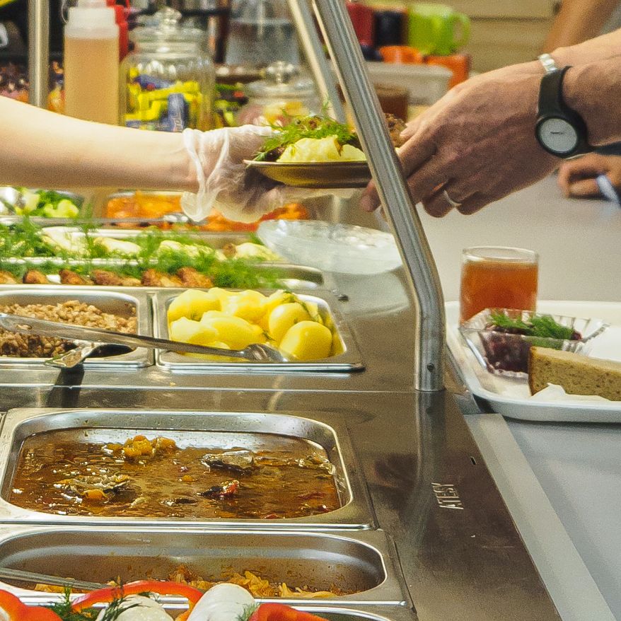 person being served food at a buffet